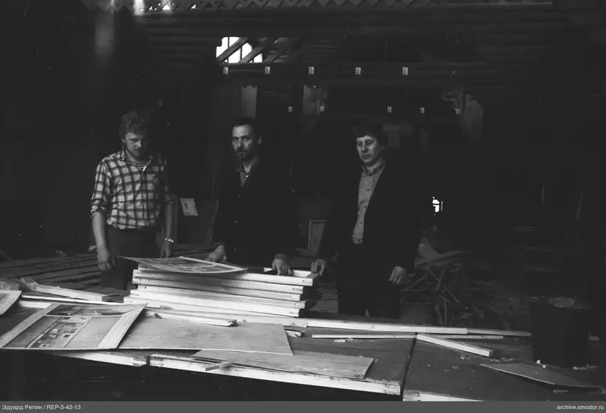 Gruppe von Männern hinter einem Tisch mit Rahmen und Papier