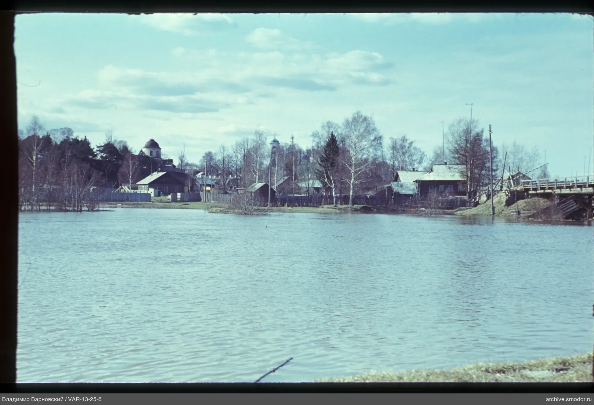 Blick auf Fluss, Dorfhäuser und Kirchtürme
