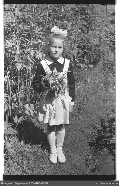 Mädchen mit Blumenstrauß auf grasbewachsenem Weg