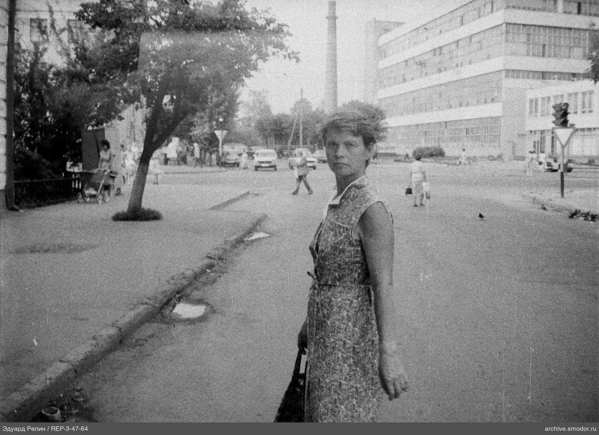 Woman in a sleeveless dress on the sidewalk