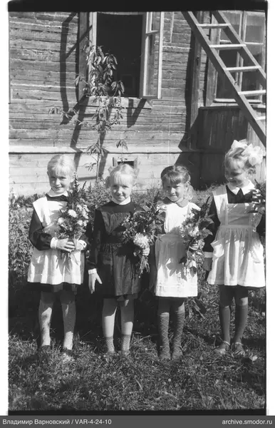 Gruppenporträt von Mädchen vor einem Holzhaus