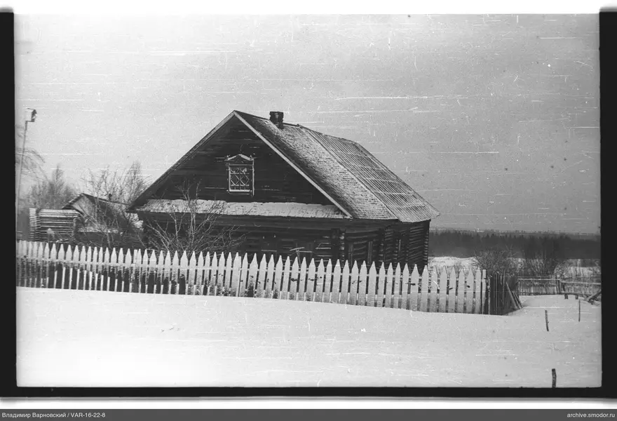Holzhaus mit Schnee und Zaun