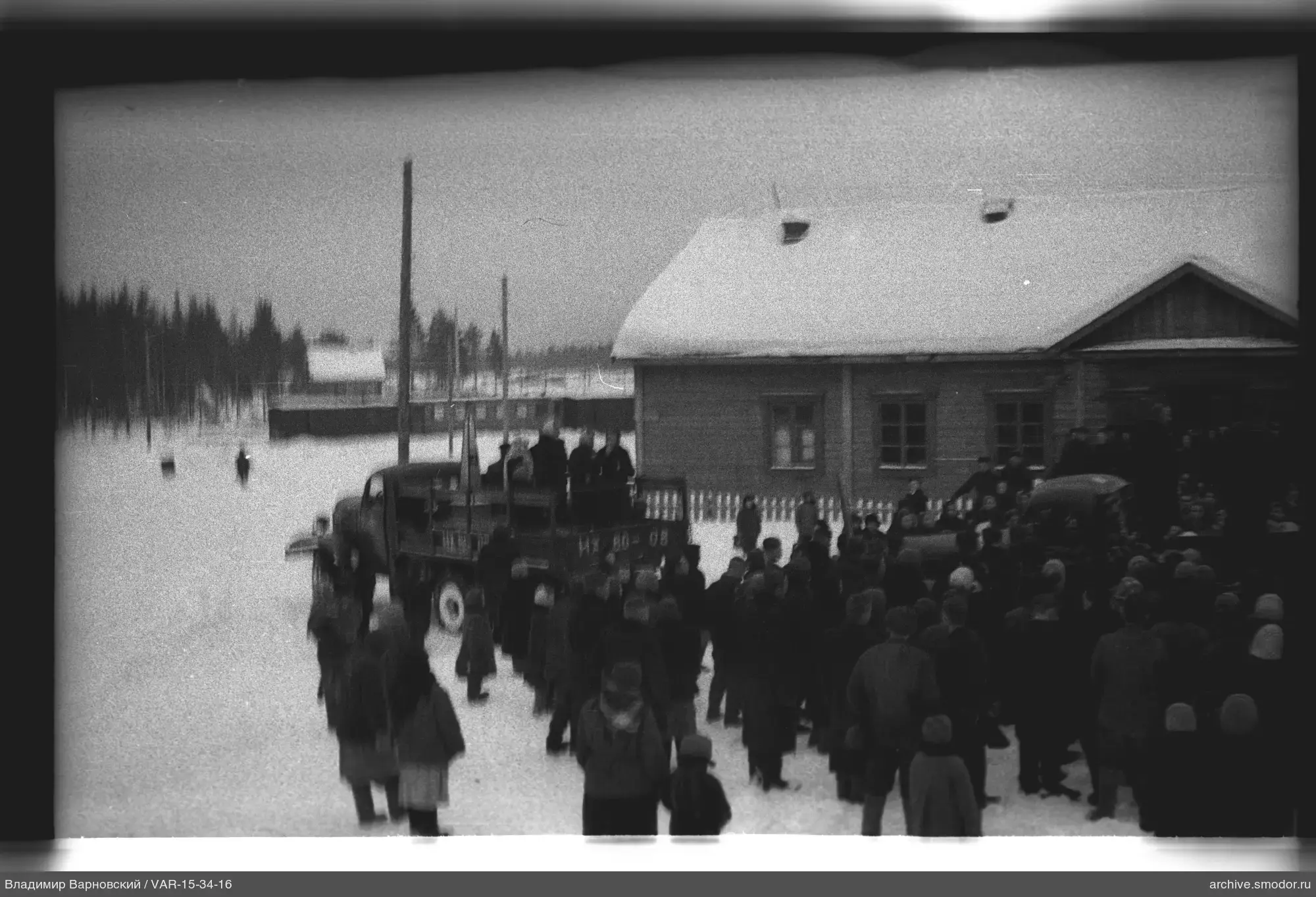 Gruppe von Menschen vor einem Haus im Schnee
