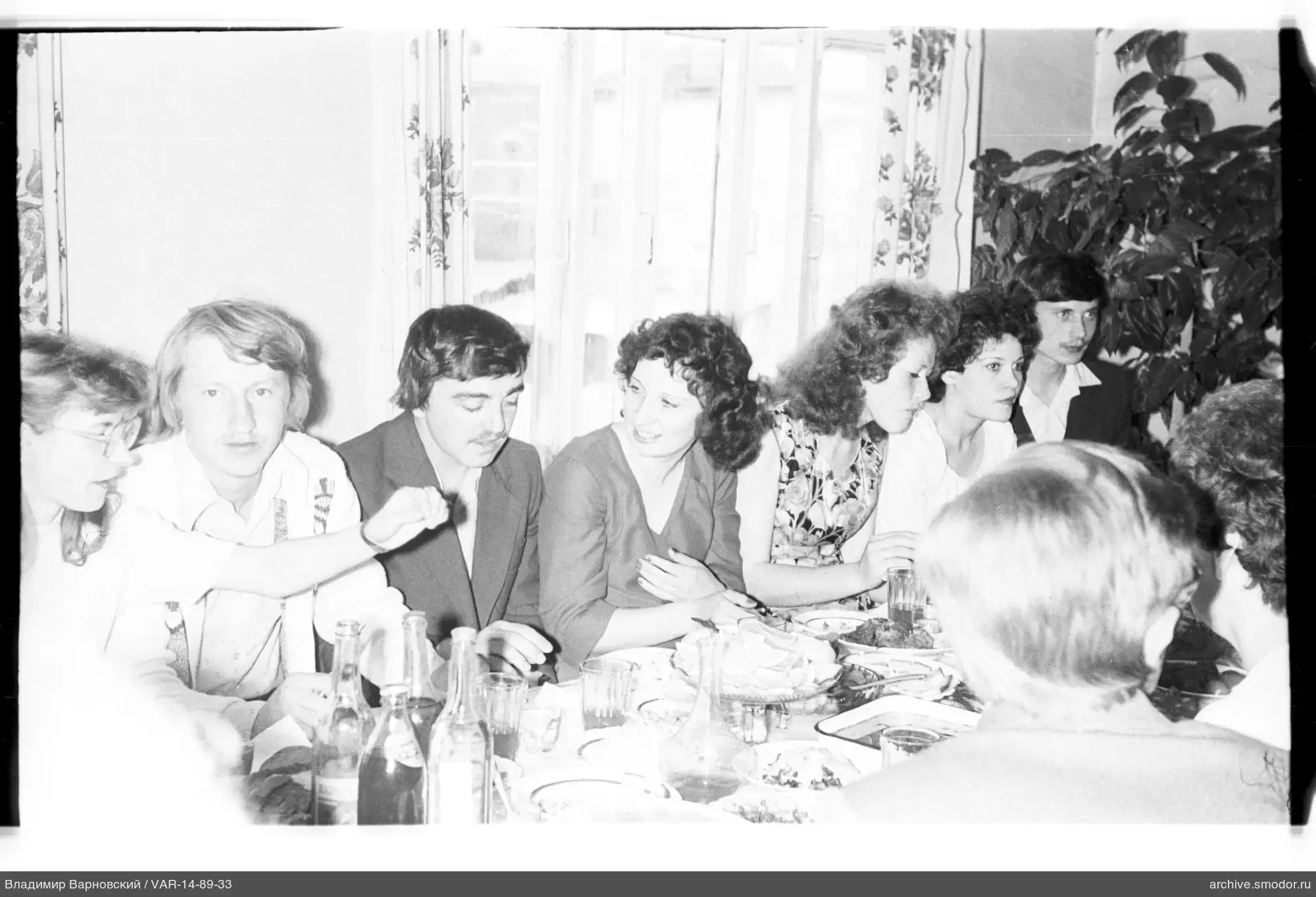 Group sitting at a table with dishes and bottles