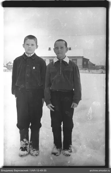 Zwei Jungen im Schnee vor einem Haus