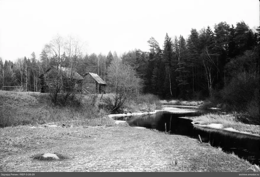 Landschaft mit Fluss und Holzhäusern