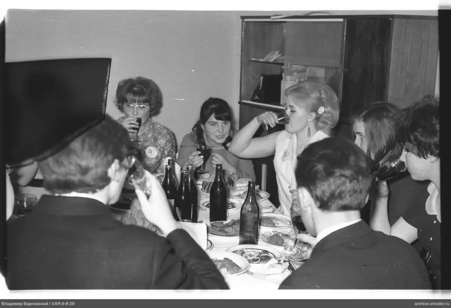 Group of people at a table with dishes and bottles
