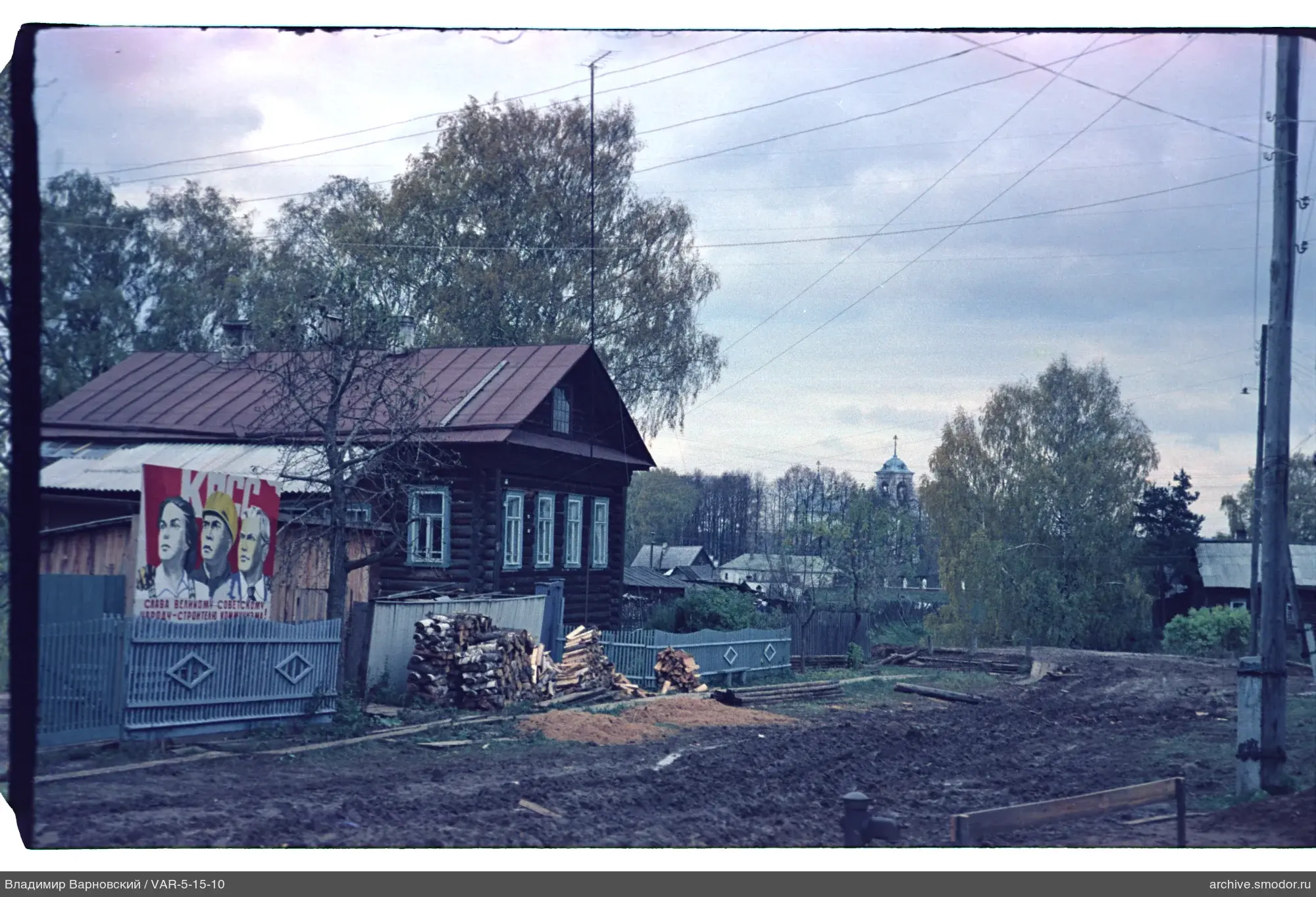 Holzhaus mit Plakat und Kirchturmglockenturm