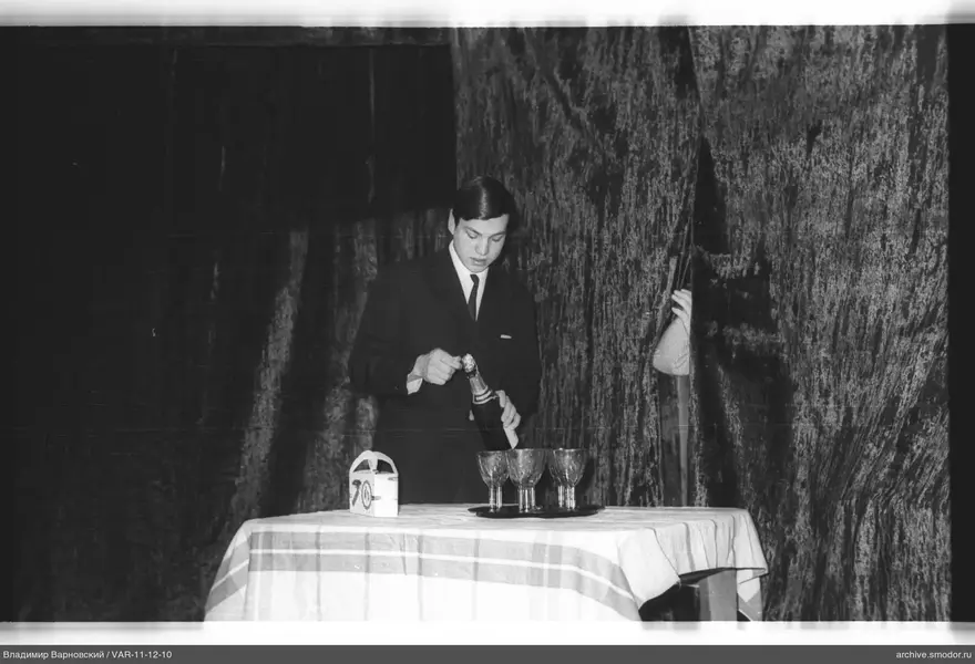 Mann öffnet Champagner am Tisch