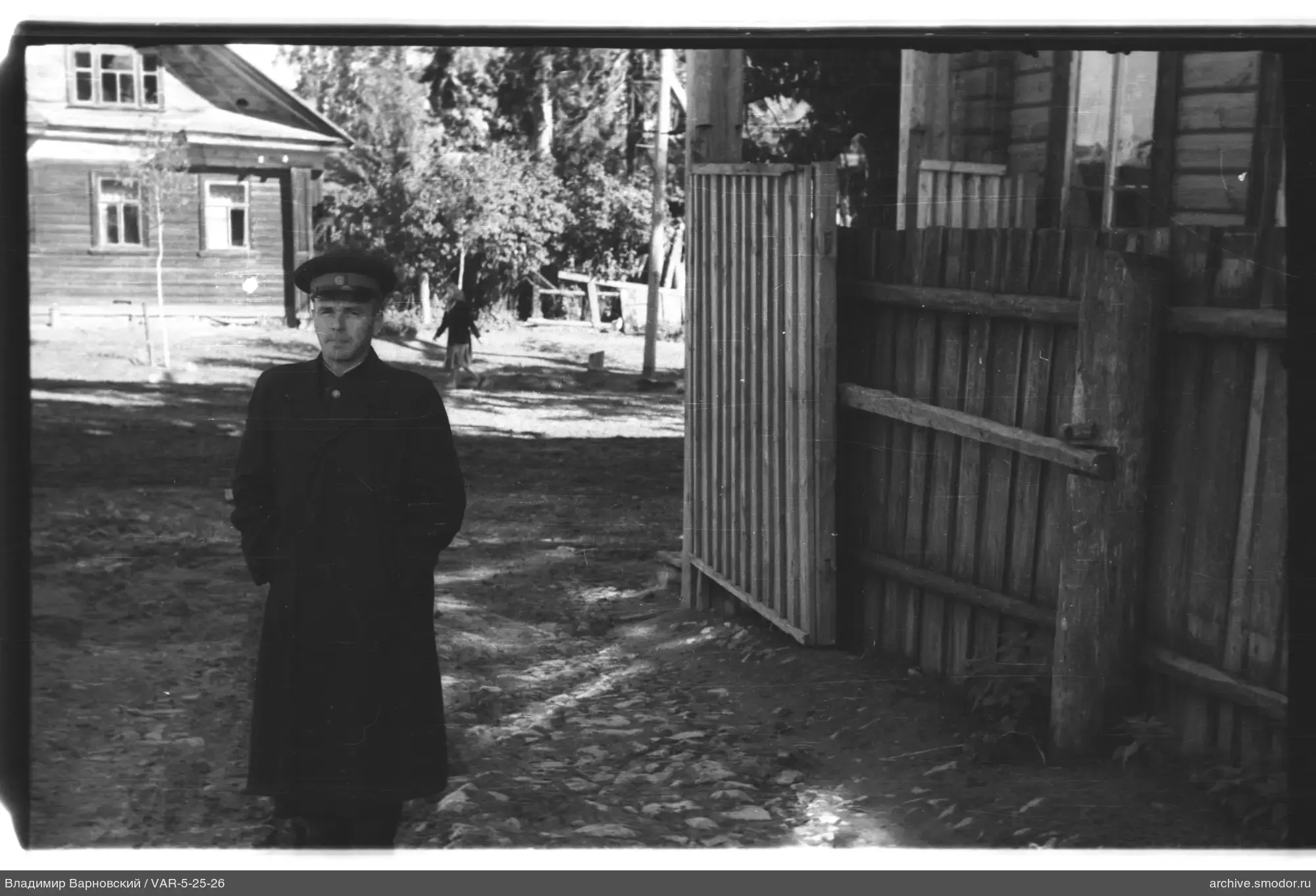 Man on dirt road near wooden house