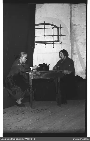 Two women sitting at a table with a teapot
