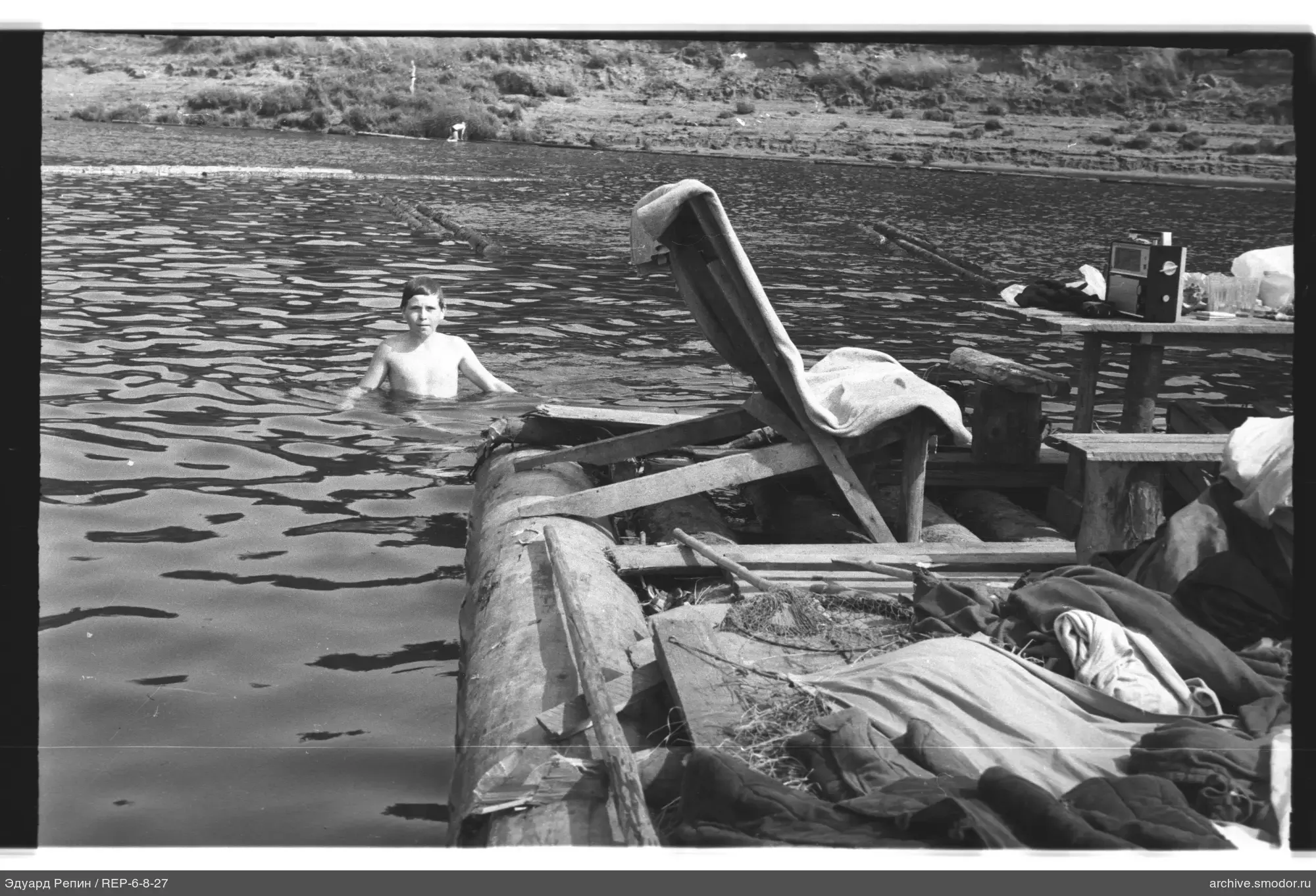 Junge im Wasser am Floß