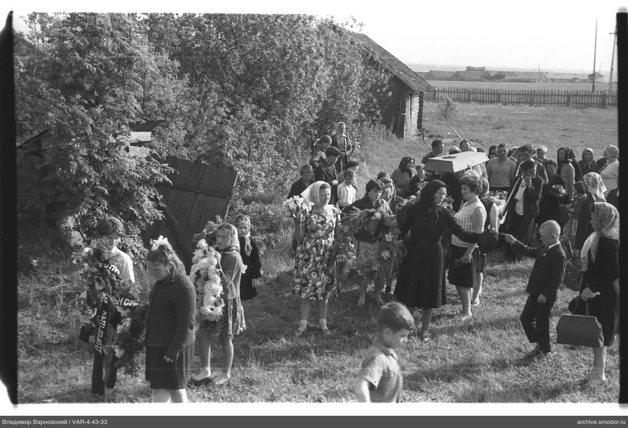 Gruppe von Menschen bei einem Holzhaus