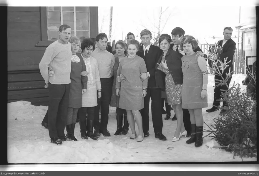 Group on snow near a wooden building