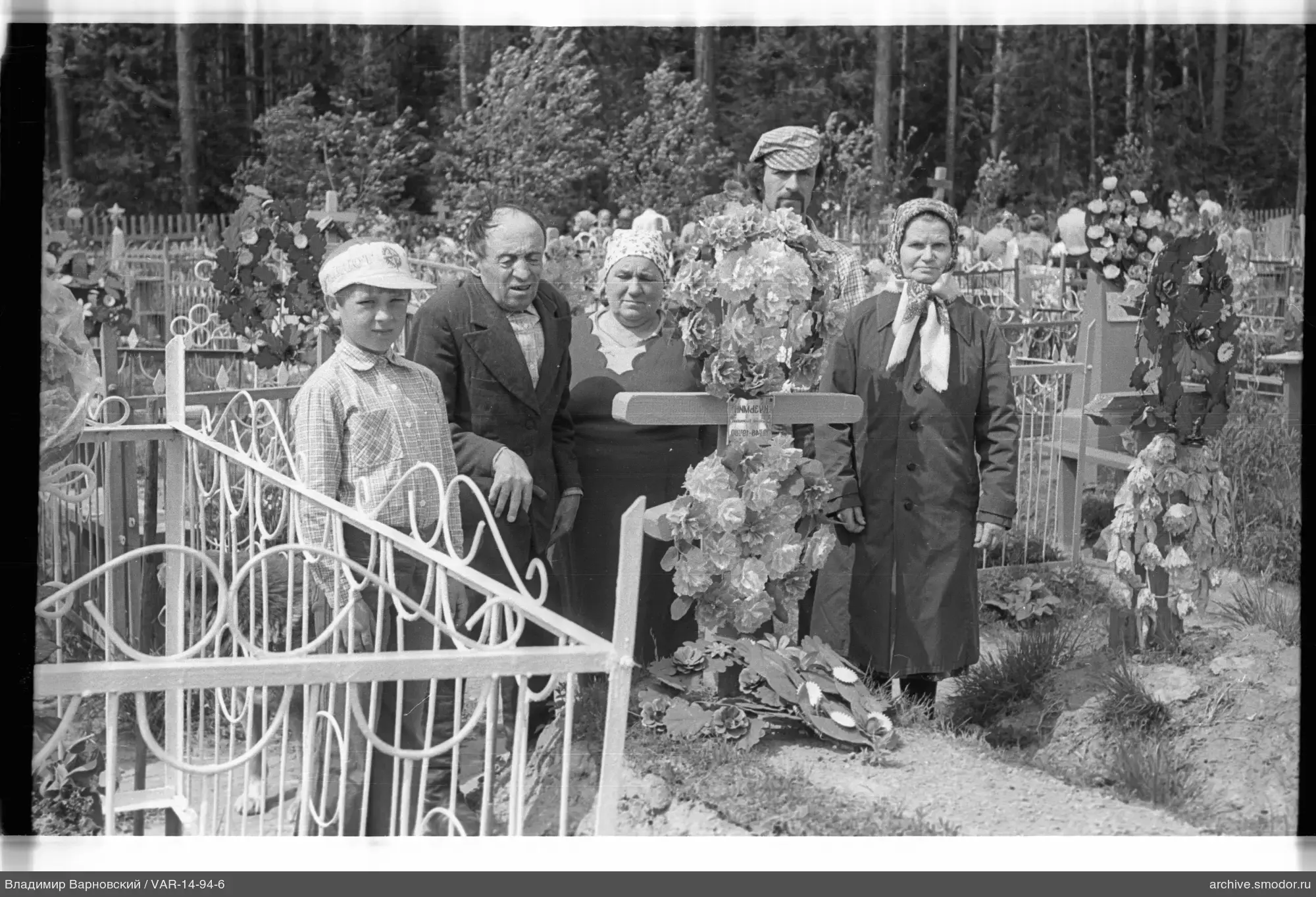Group at grave with wooden cross