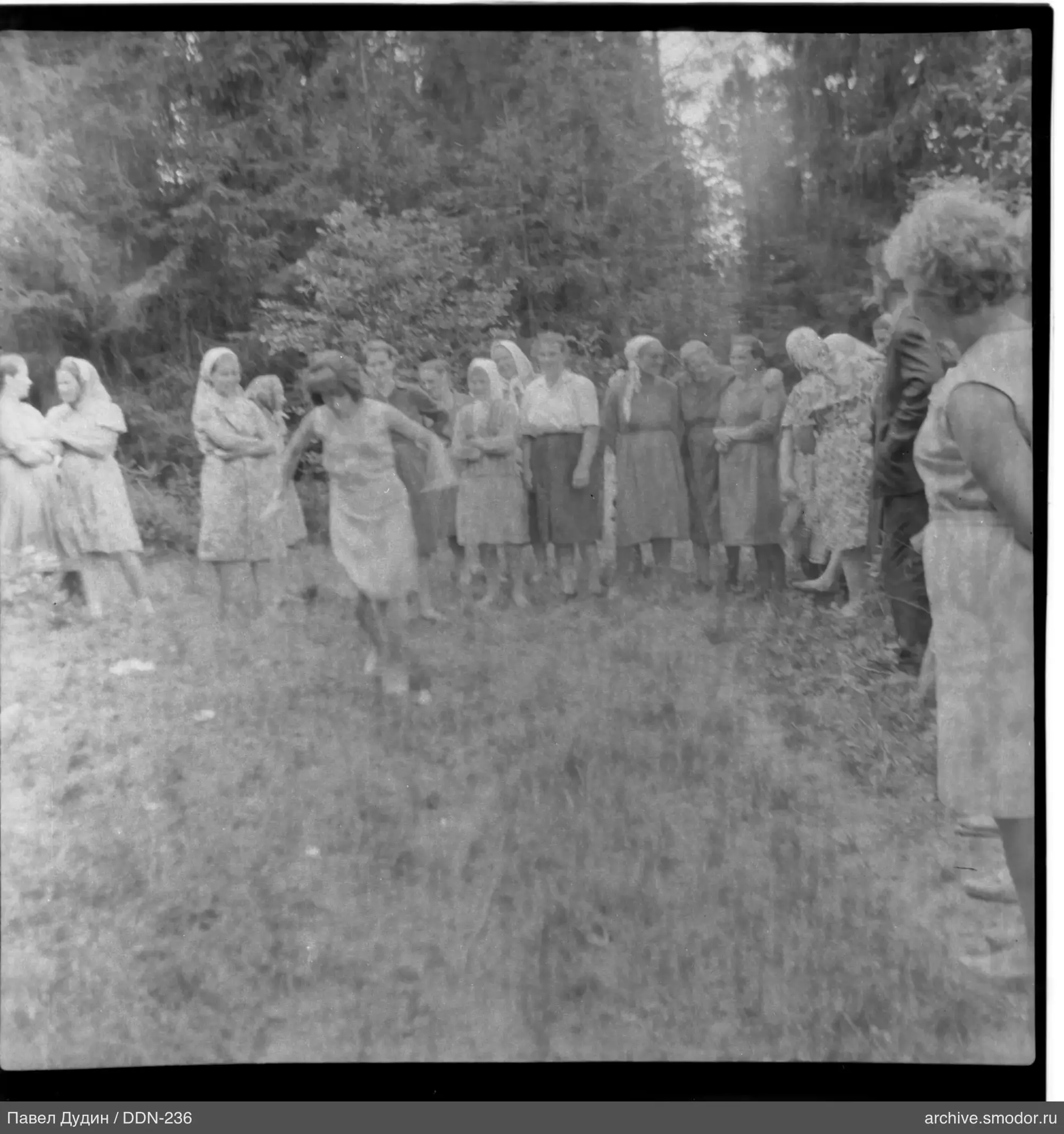 Frau in Bewegung und Gruppe auf Gras