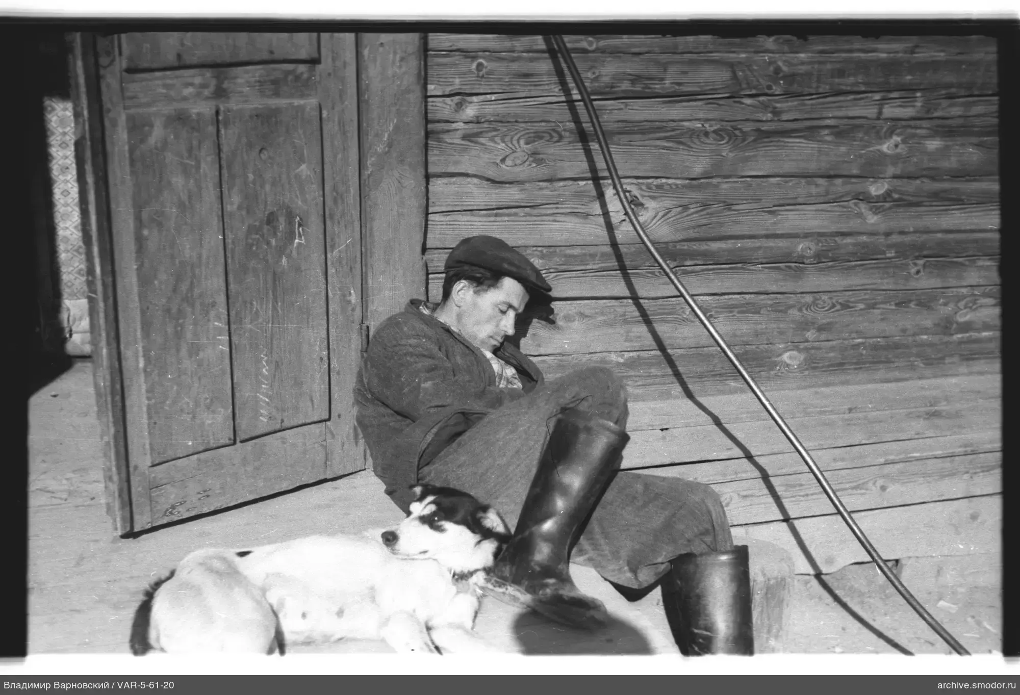 Mann mit Hund an Holzwand