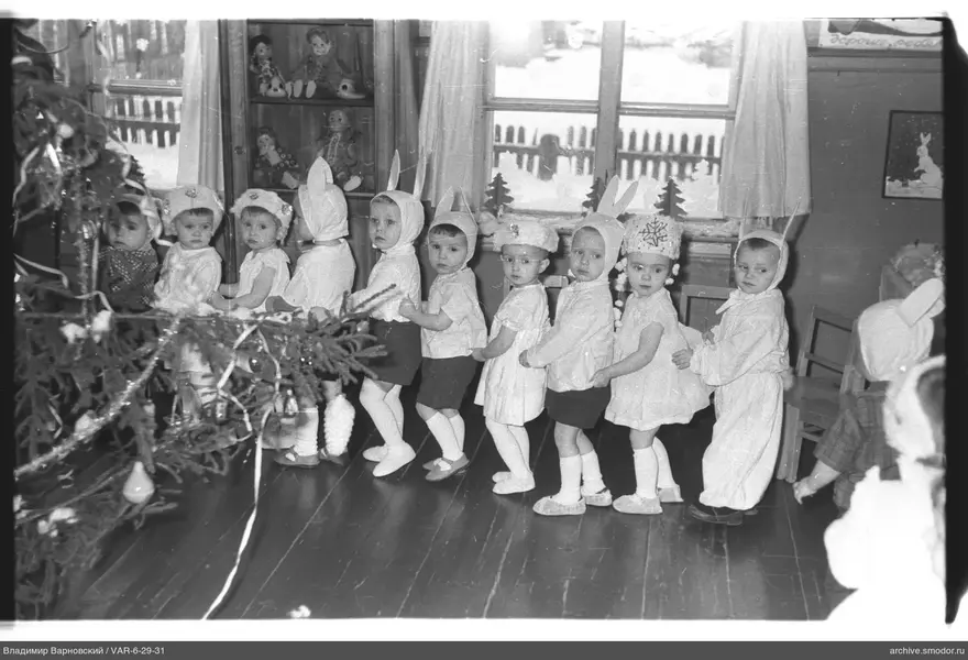 Kinder mit Weihnachtsbaumzweig und Spielzeug