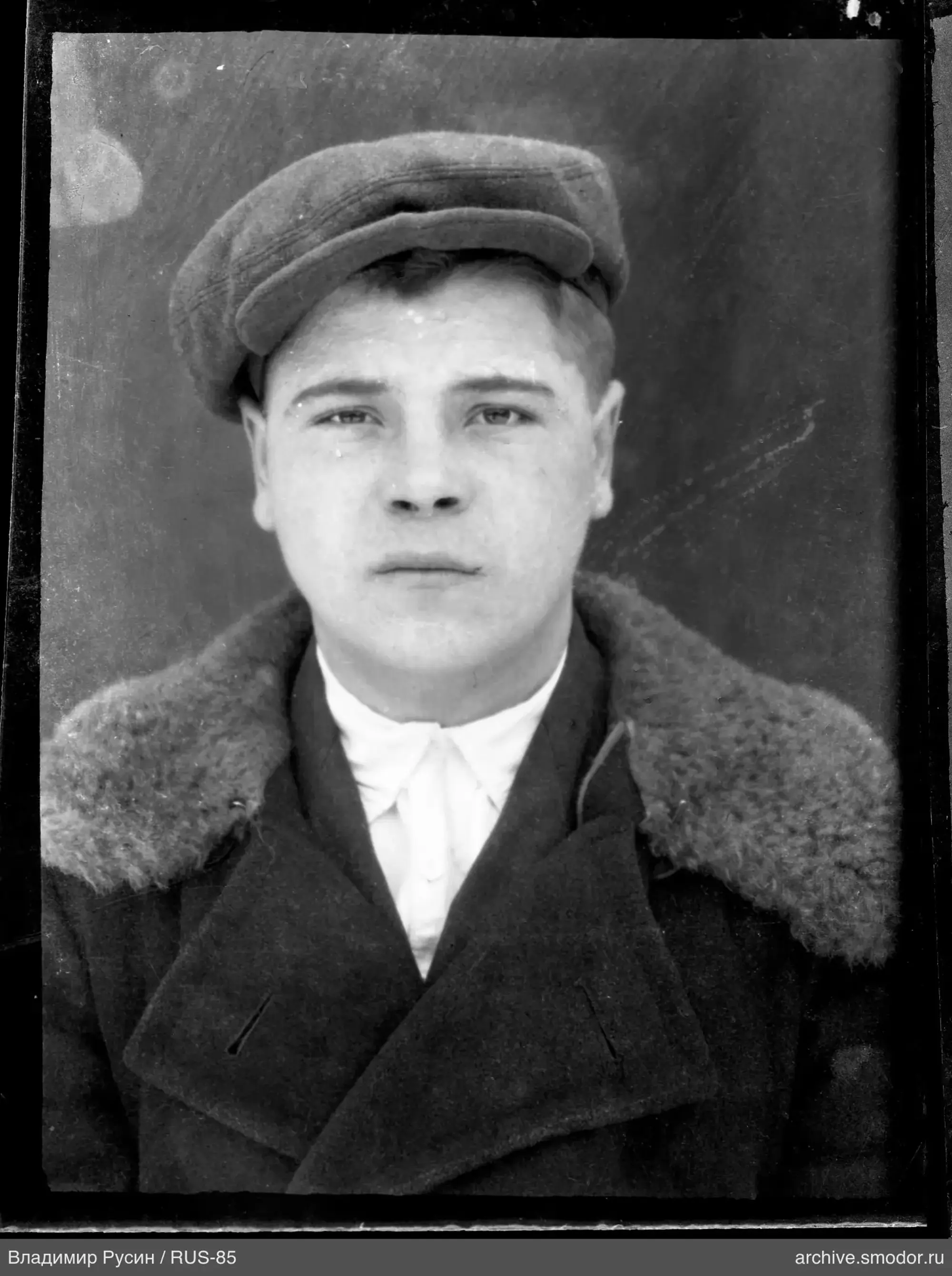Portrait of a man in a dark coat and cap