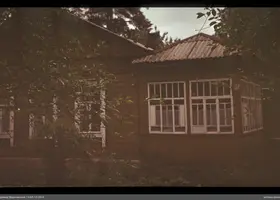 Holzhaus mit Veranda und Bäumen