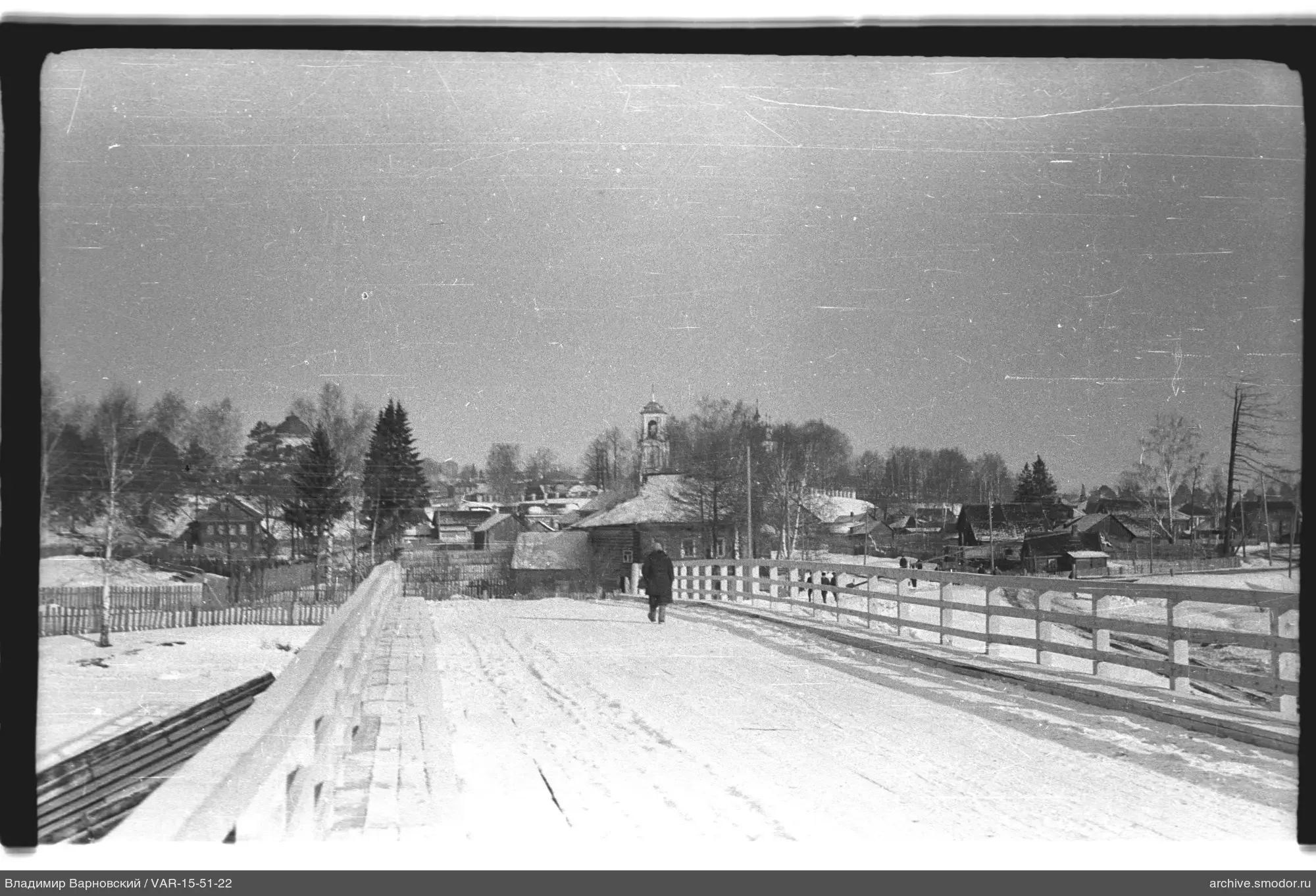 Person on snowy wooden bridge