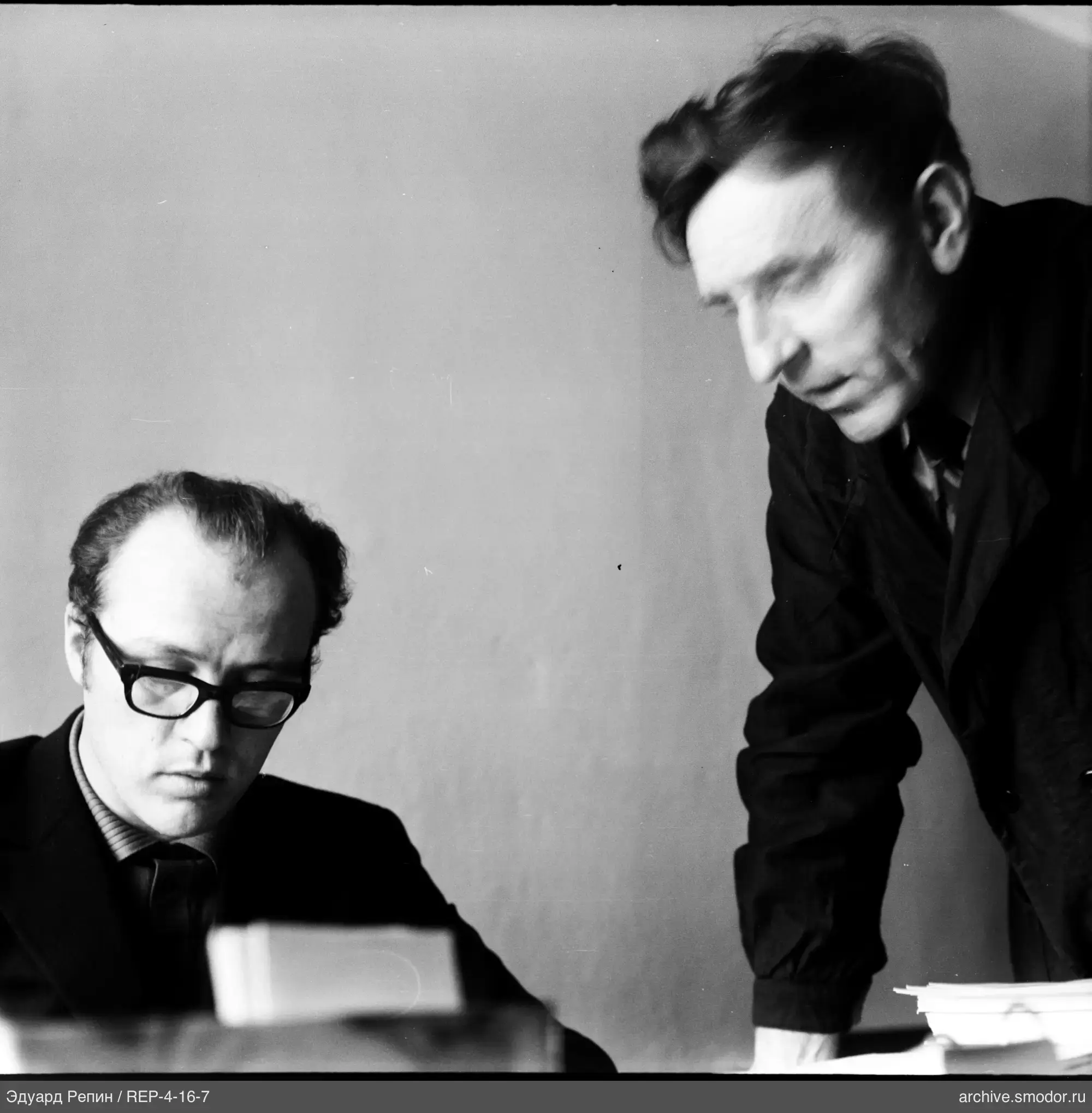 Two men and a stack of papers