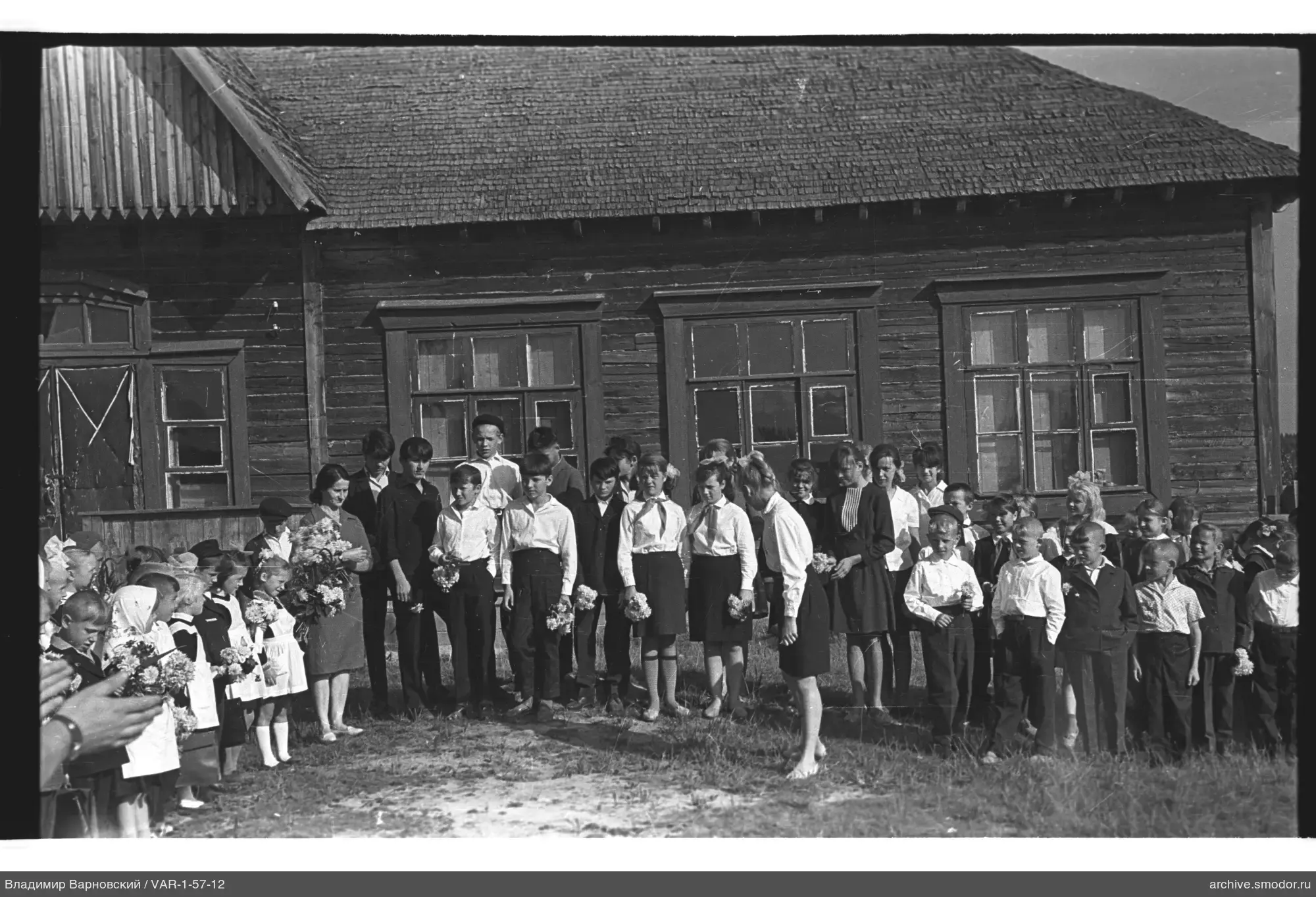 Gruppe von Kindern und Erwachsenen vor einem Gebäude