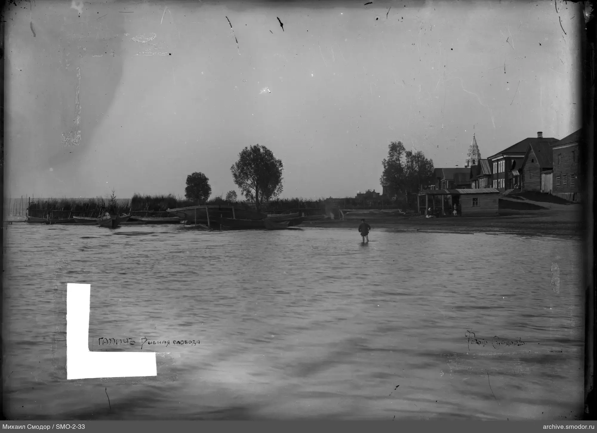 Человек в воде у береговых домов