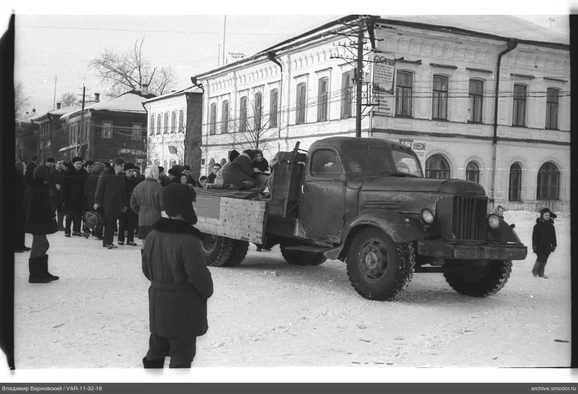 Gruppe von Menschen um einen Lastwagen im Schnee