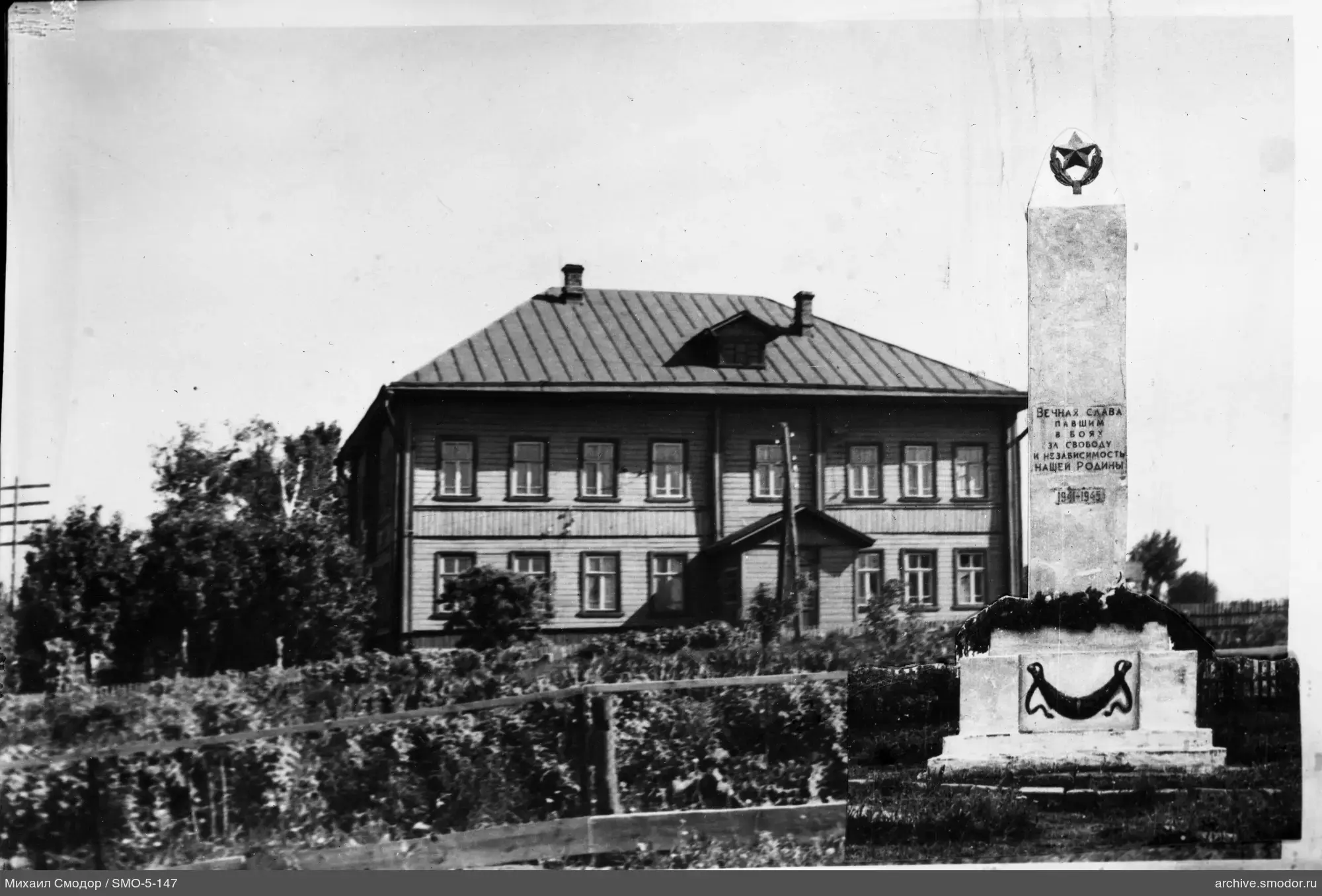 Obelisk mit Inschrift und zweistöckiges Gebäude