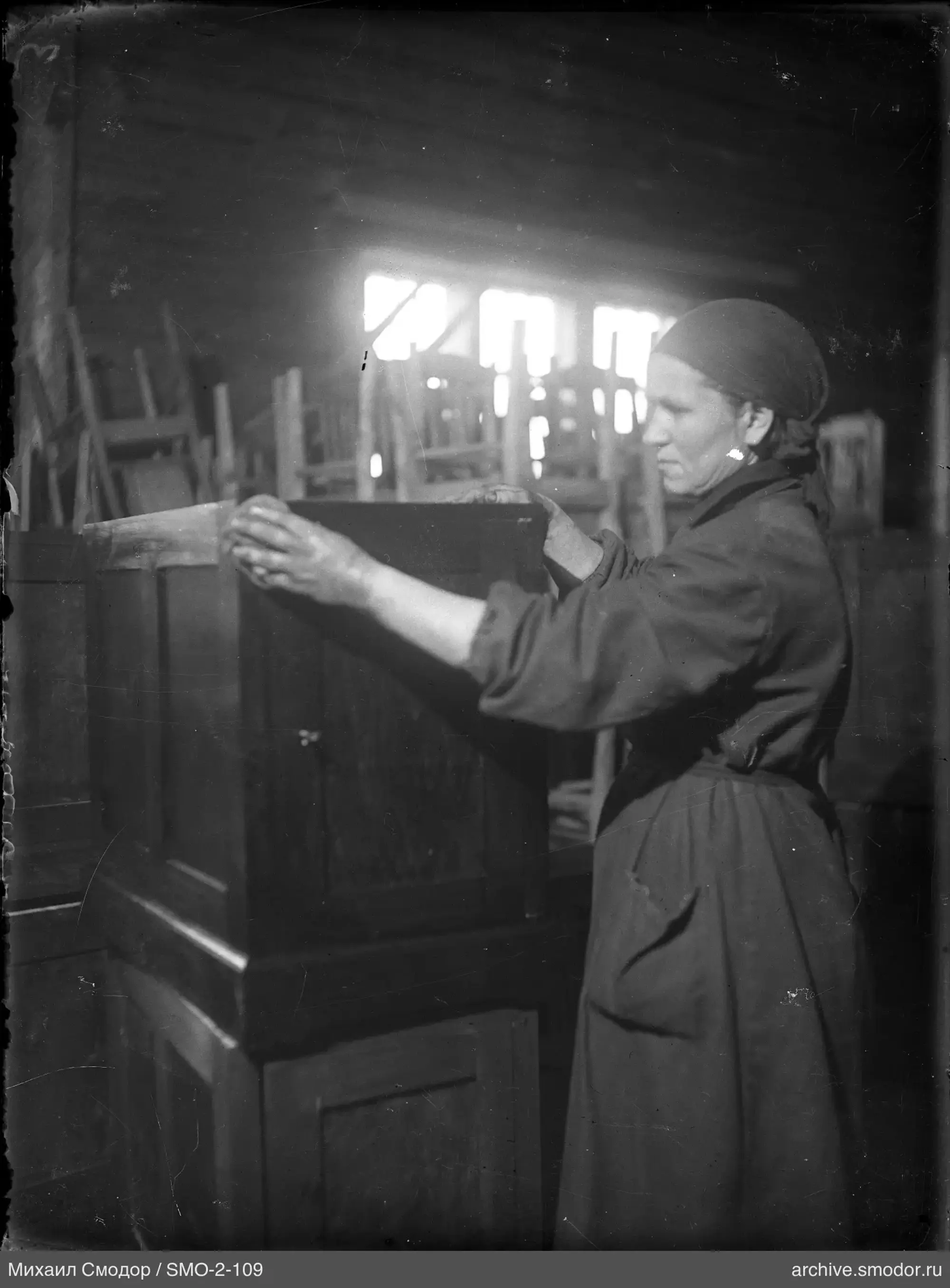Frau mit Holzkiste in Werkstatt