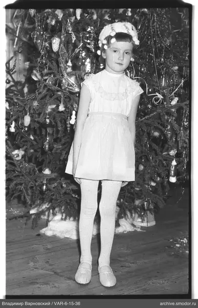 Mädchen vor geschmücktem Weihnachtsbaum