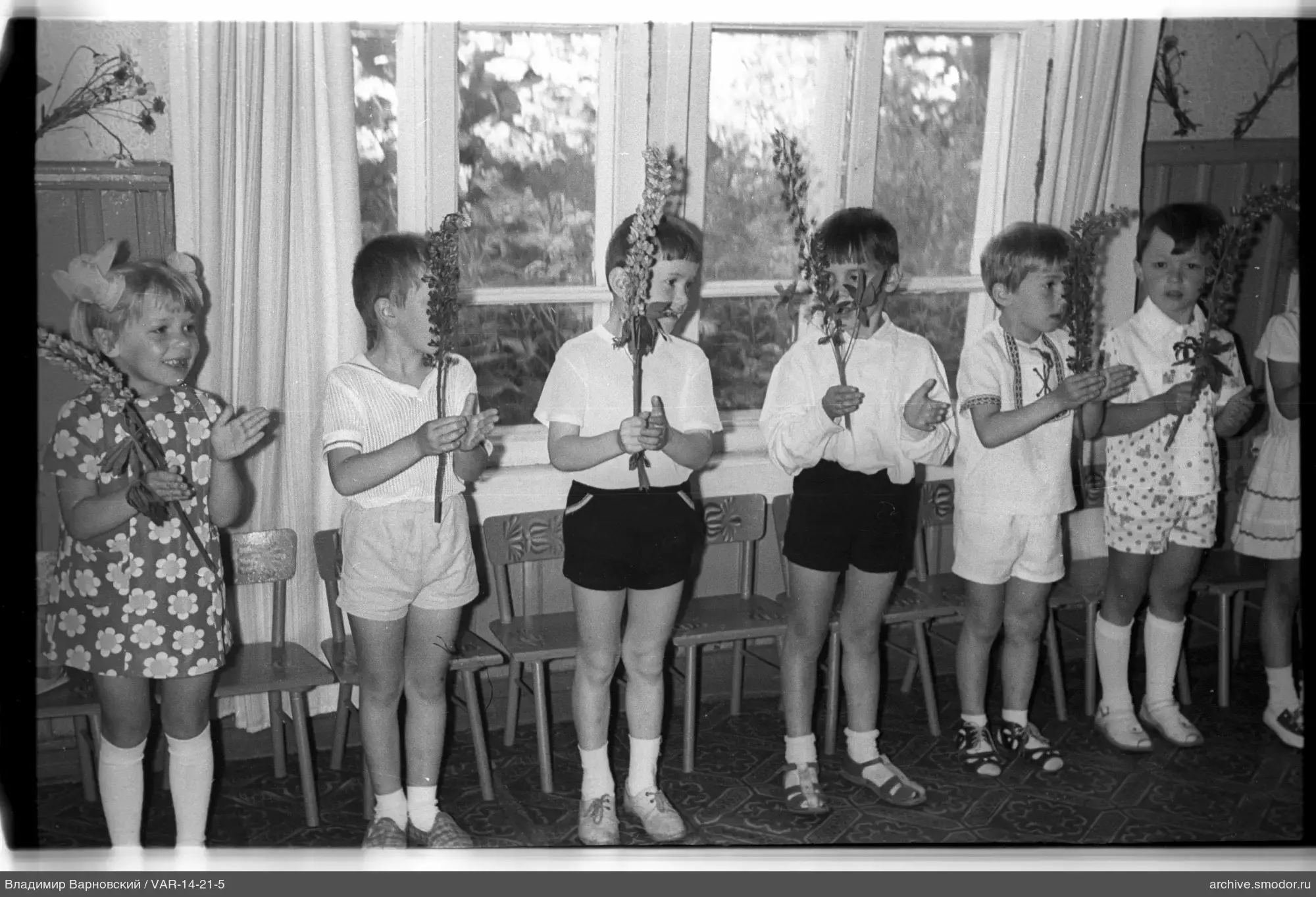 Gruppe von Kindern mit Zweigen und Blumen