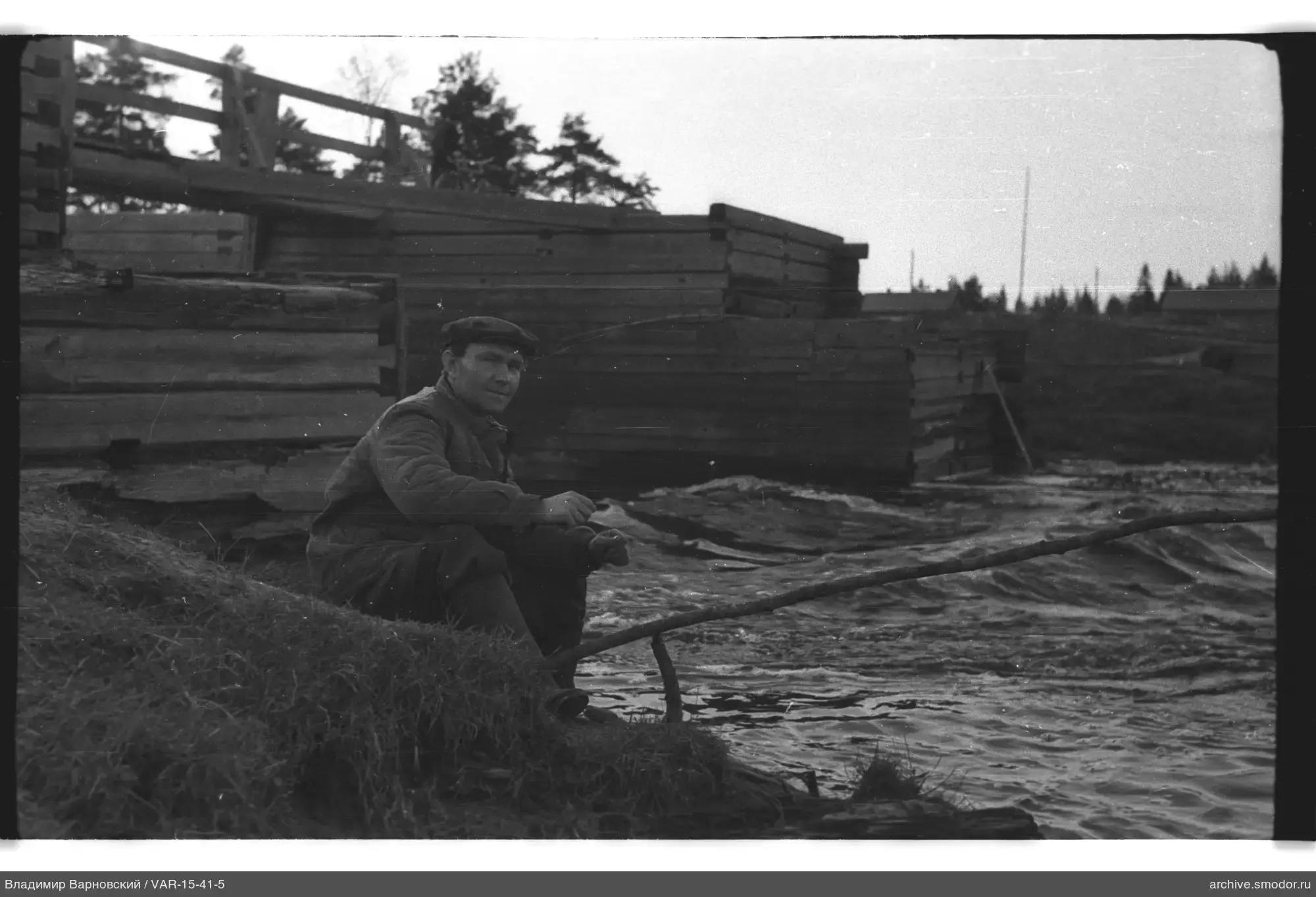 Мужчина с палкой у водоема