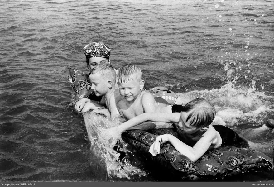 Kinder und Frau auf aufblasbarer Matratze im Wasser