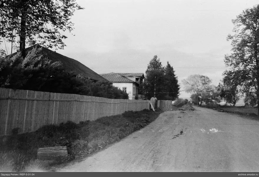 Holzzaun und unbefestigte Straße mit Spuren