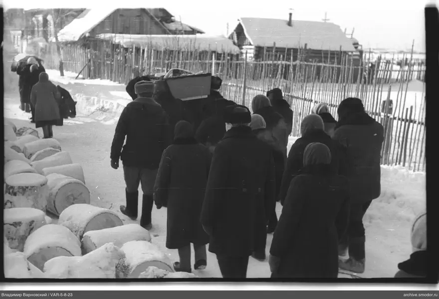 Группа людей с гробом на заснеженной улице