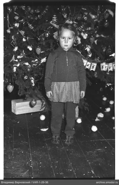Mädchen vor geschmücktem Weihnachtsbaum