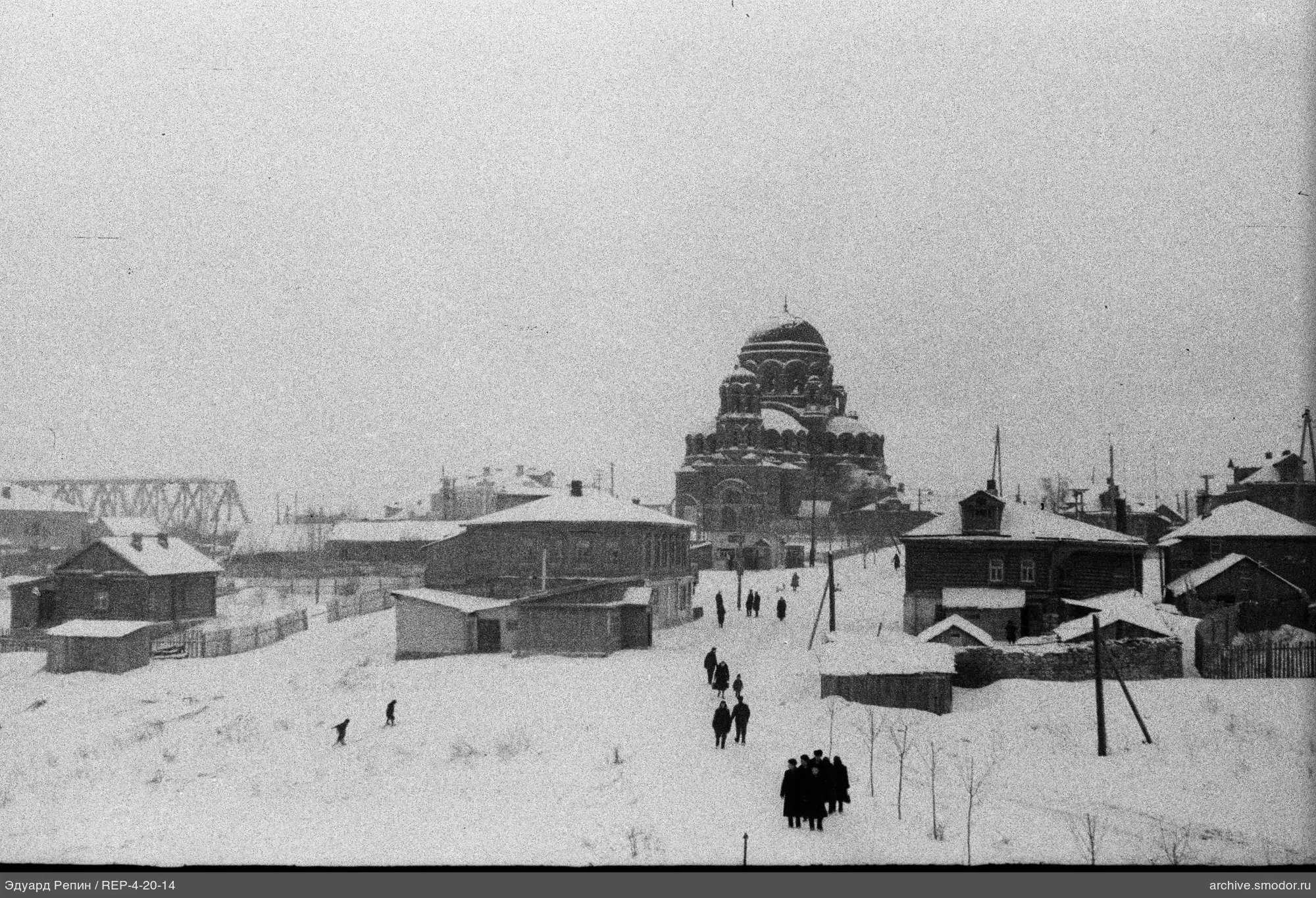 Заснеженная улица с людьми и зданием
