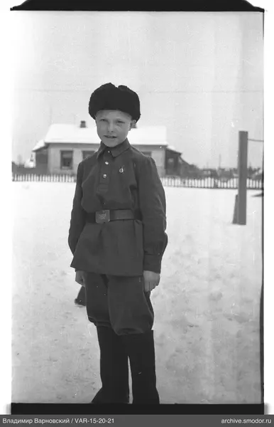 Junge in Winterkleidung vor Haus