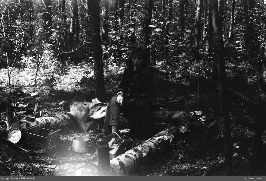 Frau auf umgestürztem Baumstamm im Wald