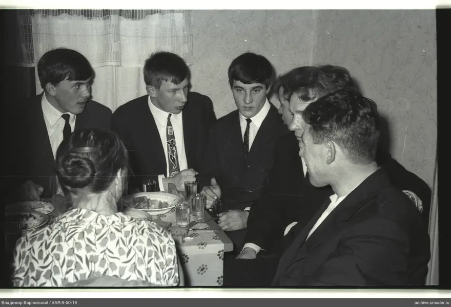 Group of people sitting at a table with dishes and glasses