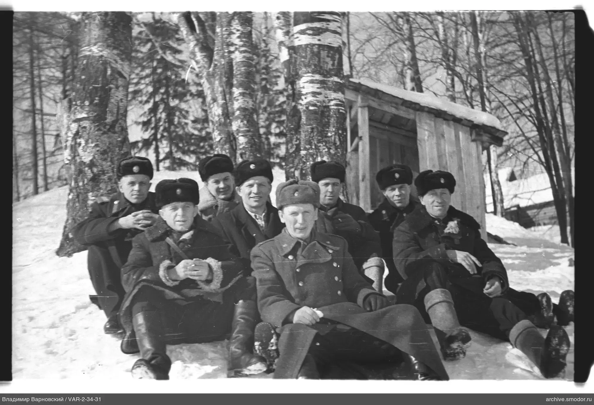 Group of men on snow near birch trees