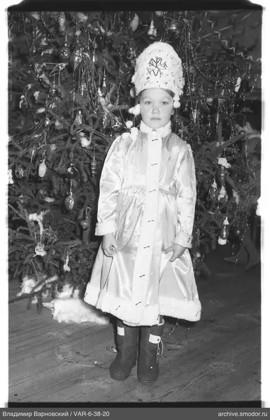 Mädchen vor geschmücktem Weihnachtsbaum