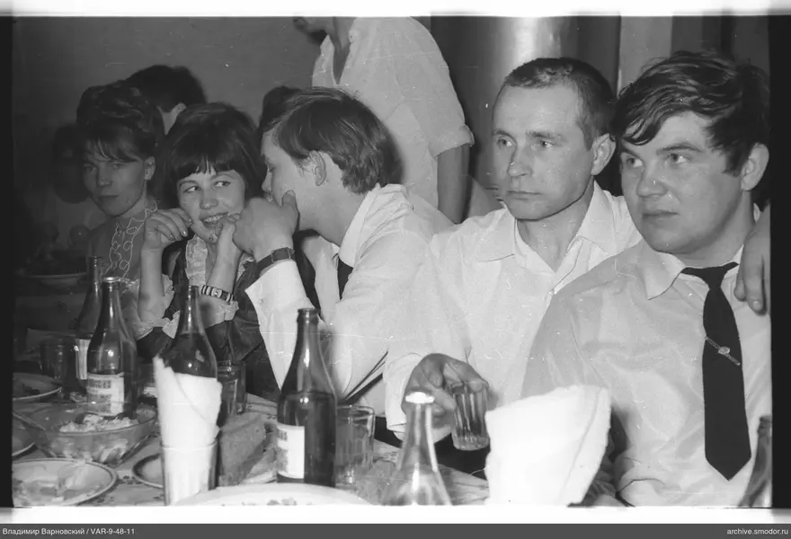 Group seated at a table with dishes and bottles