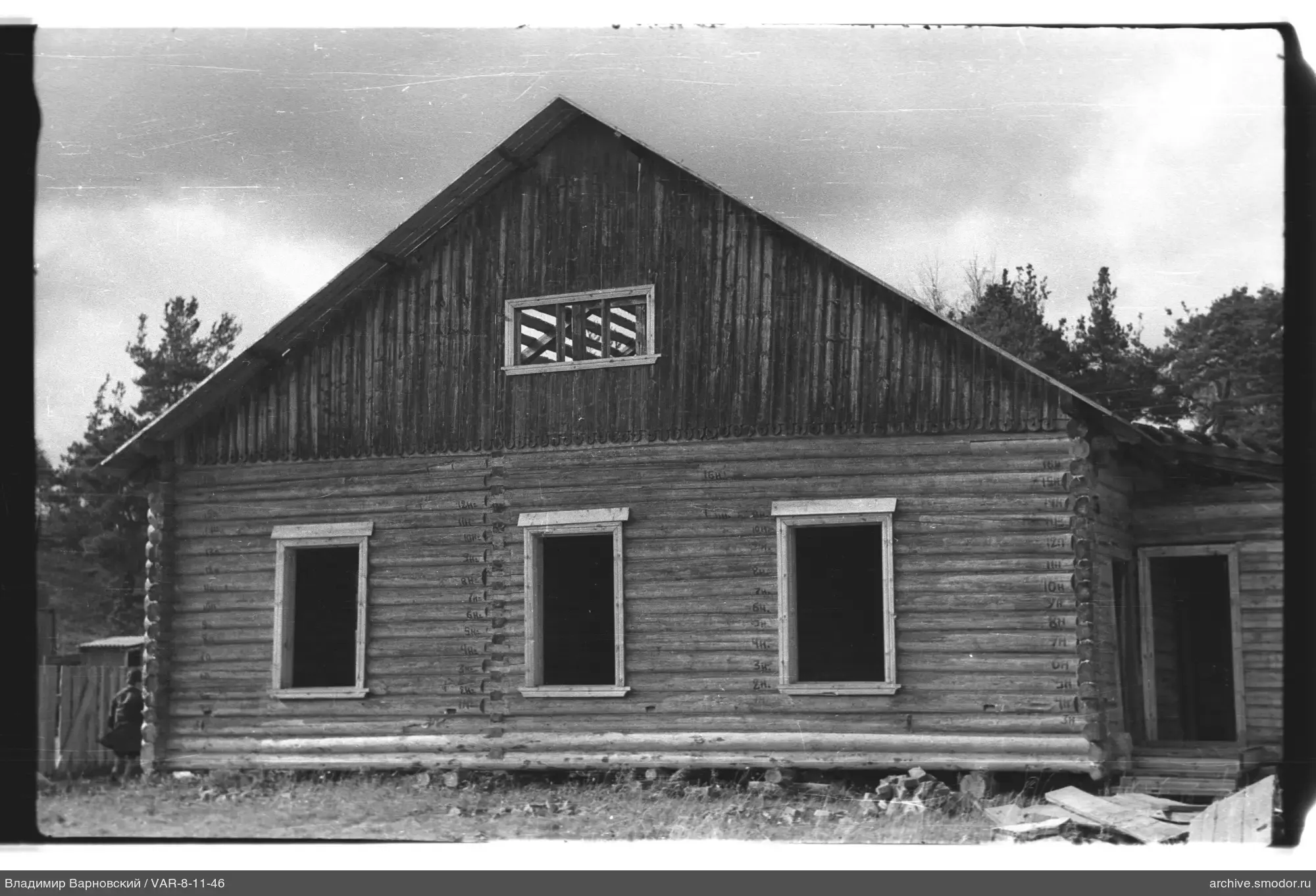 Wooden house with windows and person by fence
