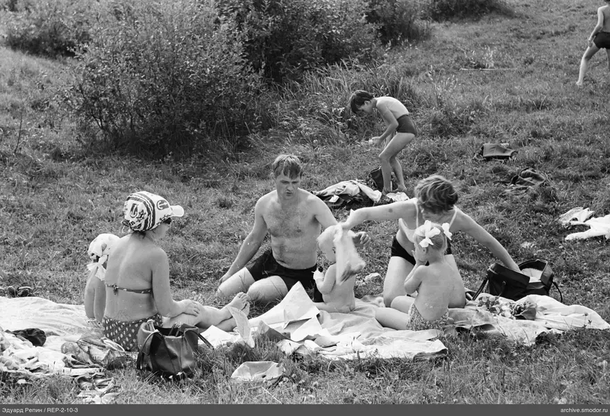Erwachsene und Kinder auf einem grasbewachsenen Hang