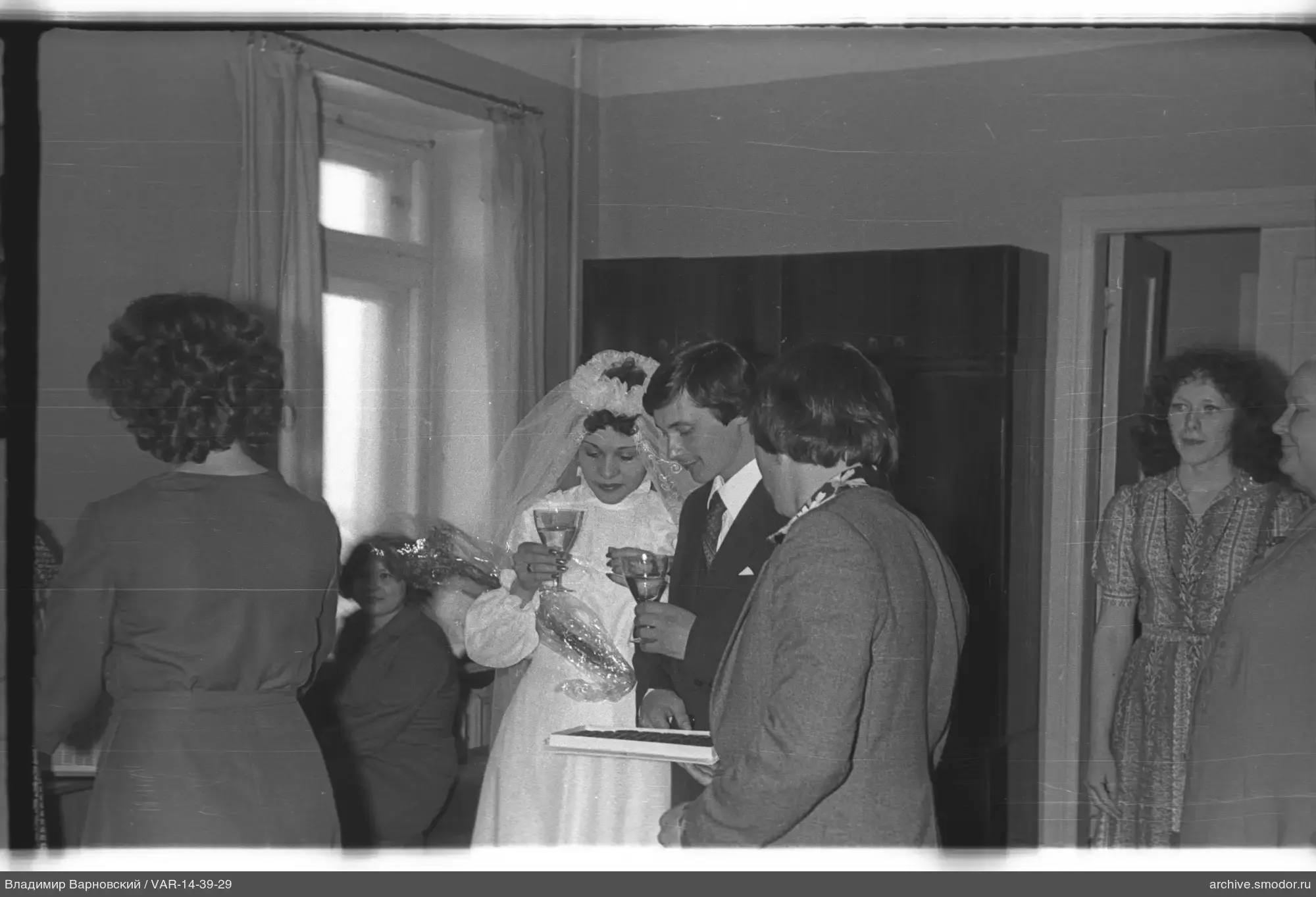 Женщина в свадебном платье и гости