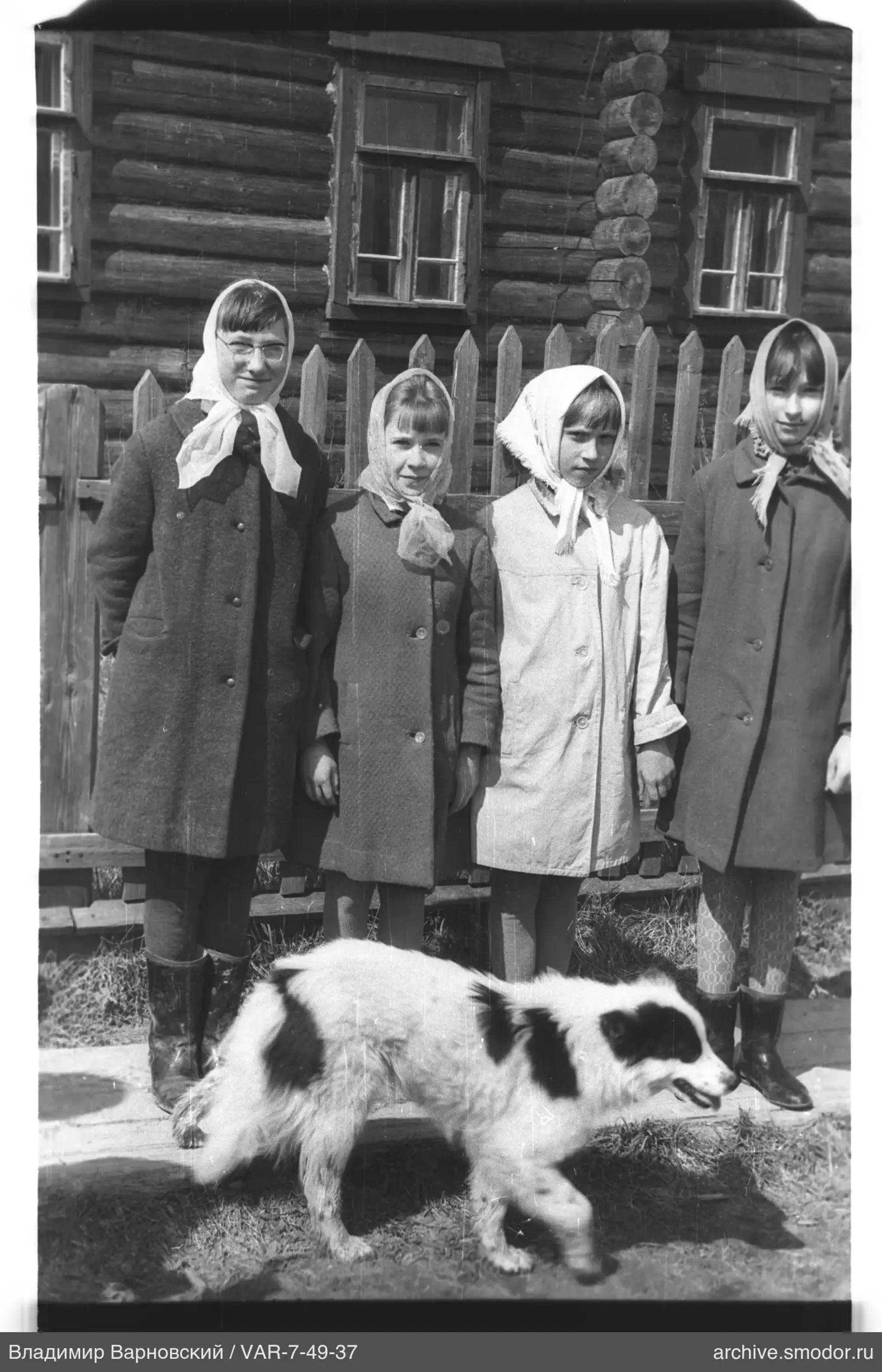 Gruppenporträt von Mädchen und Hund vor einem Haus