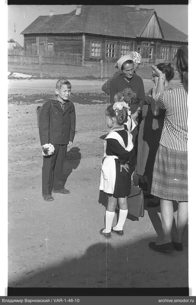 Junge mit Blumenstrauß und Mädchen in Schuluniform